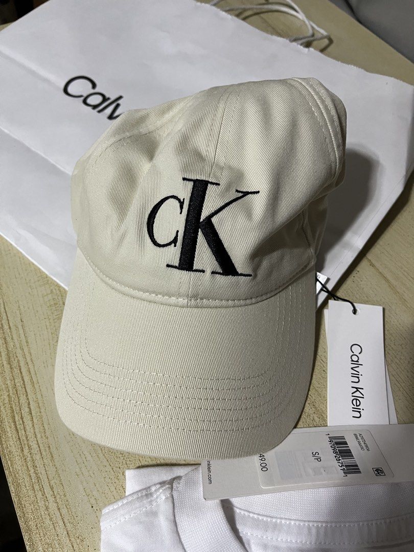 Calvin Klein Women’s Tee & Cap SET (Category: Shirts) located in Quezon City. Submitted by azarels (Listing ID 1466329332, Image 2). Description: With CK paperbag (1 PAPERBAG ONLY) Shirt needs cleaning (may dumi sa bandang colar but not used sa storage lang) Cap is One Size. Shirt is Small BOXY FIT (fit to med-large body frame) Authentic CALVIN KLEIN bought in Canada 🇨🇦 Both with Tags ‼️Fixed Price‼️ + local sf 📍Project 8, Quezon City.