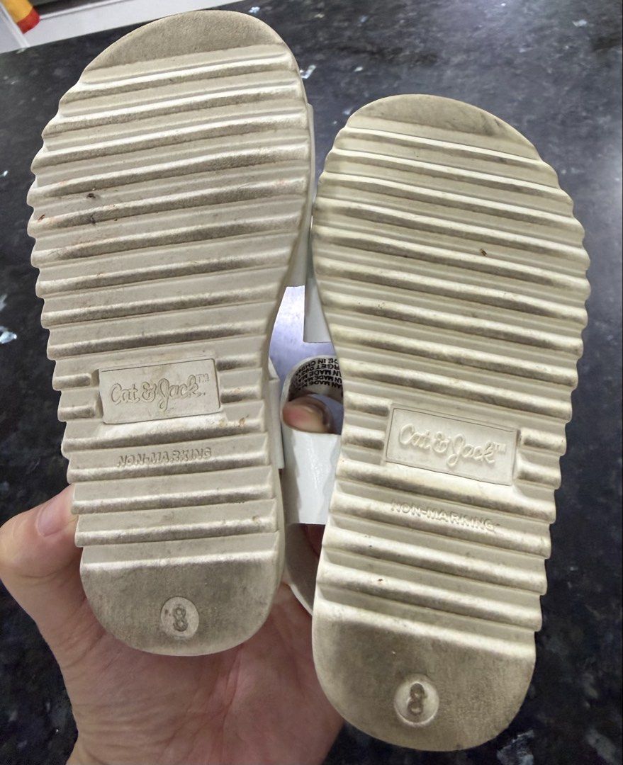 Cat & Jack Kids White Sandals Size 8 (Category: Babies & Kids Fashion) located in Calamba. Submitted by sofiesmerch (Listing ID 1466208393, Image 3). Description: - Brand: Cat & Jack - Size: 8 Toddler - Color: White with neutral beige footbed - Features: Adjustable ankle strap and front buckle detail - Sole: Non-marking, textured sole for safety - Condition: Moderate wear on tread and toe areas from normal playtime use.