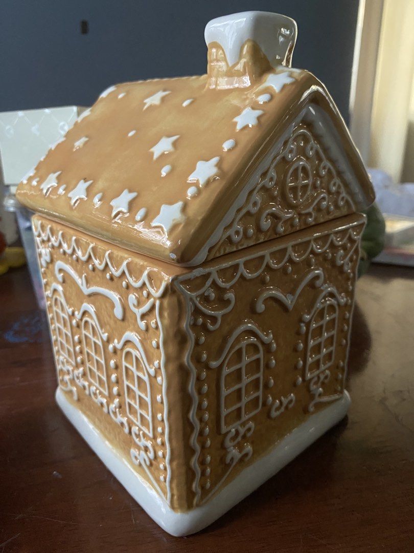 Ceramic Gingerbread House Cookie Jar Holiday Decor (Category: Food Organization & Storage) located in Cavite. Submitted by tatashop_sky (Listing ID 1466302784, Image 2). Description: - Material: High-quality ceramic gingerbread house cookie jar - Design: Removable roof lid with a white frosted chimney, iced patterns, windows, stars, and a gingerbread man by the door - Base: Charming white snowy base - Use: Ideal for storing holiday treats or as a