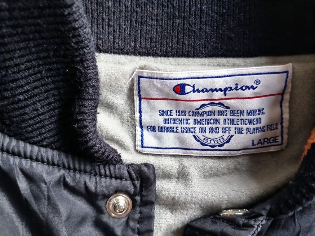 Champion Black Bomber Jacket with Orange Striped Ribbing (Category: Coats, Jackets and Outerwear) located in Manila. Submitted by nisayy13 (Listing ID 1466242581, Image 3). Description: - Brand: Champion - Color: Black with orange and black striped collar and cuffs - Closure: Snap button front - Details: Embroidered Champion logo patch on right chest, two side pockets - Material: Lightweight, great for easy layering.