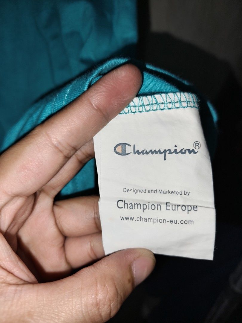 Champion Teal Script Logo T-Shirt XL (Category: Tshirts & Polo Shirts ) located in Baguio. Submitted by fordaluvofthrift2600 (Listing ID 1466169436, Image 3). Description: - Brand: Champion - Color: Teal - Size: M FIT TO L - Fit: Relaxed fit with short sleeves - Design: White cursive script logo embroidered on chest - Details: Small 'C' patch on left sleeve and woven label near bottom hem - Authenticity: Includes inner size tag and Champion Europ