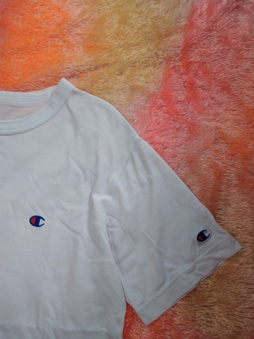 Champion White T-Shirt Medium>Width 19/Length 27 (Category: Shirts) located in San Isidro, Davao Oriental. Submitted by nelthrift30 (Listing ID 1466179771, Image 2). Description: - Brand: Champion - Color: White - Size: Medium - Design: Classic crew neck with short sleeves - Details: Small embroidered Champion logo patch on the chest and left sleeve - Condition/Tag: Authentic American Athleticwear interior tag - Style: Clean, minimalist, and easy