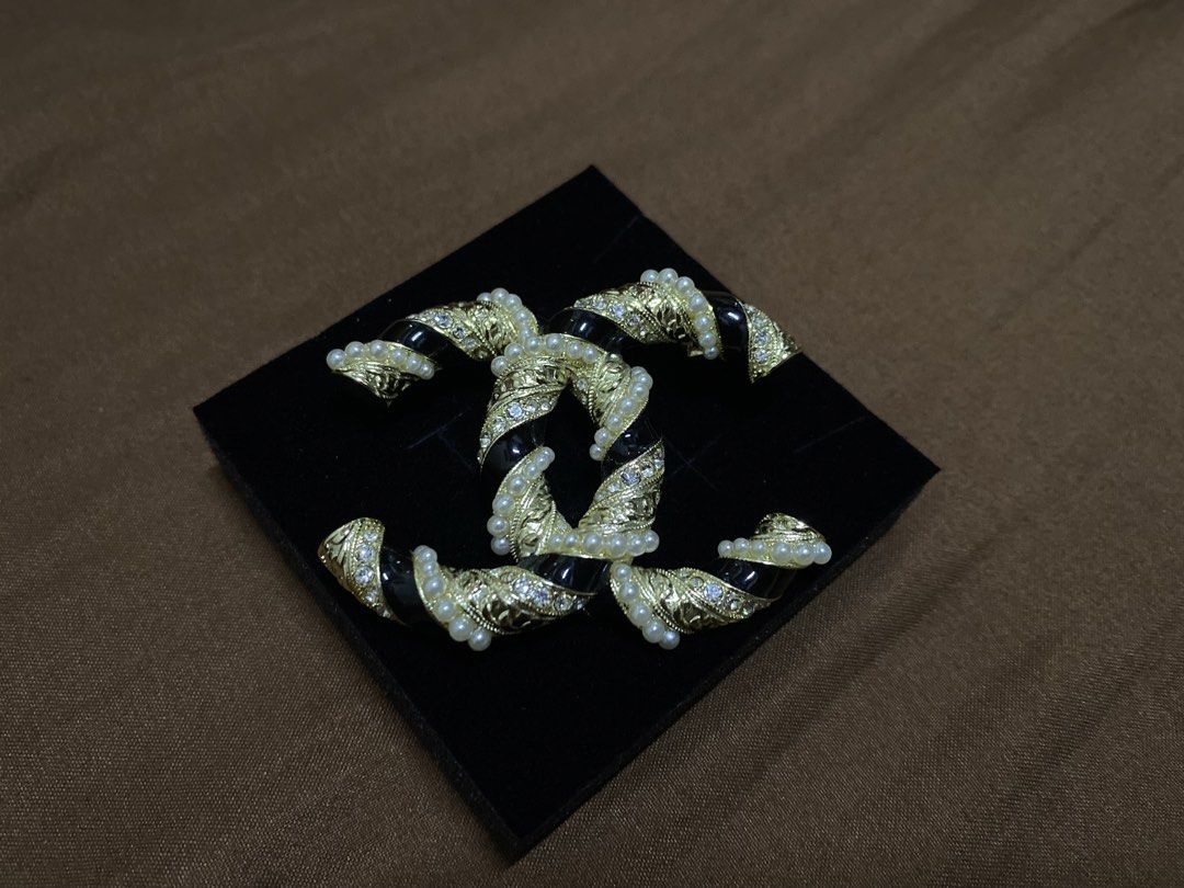 Chanel Brooch (Category: Luxury Accessories) located in Manila. Submitted by xielega (Listing ID 1466332391, Image 2). Description: Chanel CC Brooch featuring the iconic interlocking CC logo with black enamel, faux pearls, and crystal accents. Gold-tone finish with secure pin closure. Hallmarked "CHANEL - Made in France." Pre-owned and in very good condition with minor signs of wear on the back. Elegant accessory for blazers, dresses, scarves, ha
