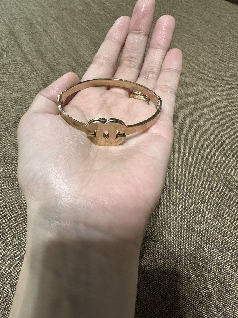 Chanel gold interlocking CC logo hinged bangle bracelet (Category: Bracelets) located in Dagupan City. Submitted by vallureph (Listing ID 1466162093, Image 1). Description: - gold-tone metal hinged bangle bracelet - Features iconic interlocking Chanel CC logo in the center with engraved branding - Secure side clasp closure for easy and safe wear - Classic, versatile design that matches any outfit - Comfortable fit for most standard wrist sizes - 