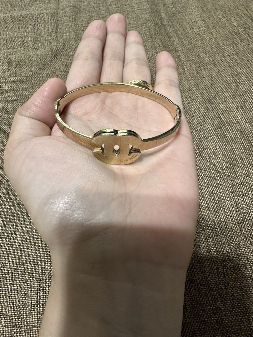 Chanel gold interlocking CC logo hinged bangle bracelet (Category: Bracelets) located in Dagupan City. Submitted by vallureph (Listing ID 1466162093, Image 2). Description: - gold-tone metal hinged bangle bracelet - Features iconic interlocking Chanel CC logo in the center with engraved branding - Secure side clasp closure for easy and safe wear - Classic, versatile design that matches any outfit - Comfortable fit for most standard wrist sizes - 