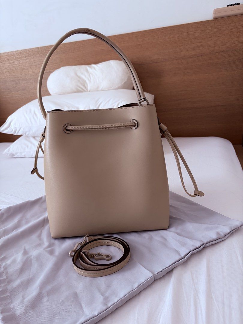 MUST GO! Charles & Keith Beige Bucket Bag with Strap (Category: Cross-body Bags) located in Las Pinas. Submitted by sabs28 (Listing ID 1466197393, Image 3). Description: Clean structured shape, drawstring closure across the top. Detachable matching strap included along with dust bag. Interior has a spacious brown lining with a reinforced base. Handle has minor scuffs, top and below. Flaws shown in pics. ** with dust bag and paper bag ** retails a