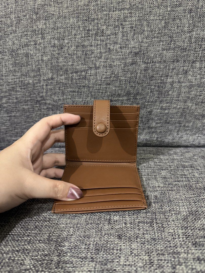 Charles & Keith Brown Card Holder Wallet (Category: Wallets & Card holders) located in Manila. Submitted by hannabananahhh (Listing ID 1466286969, Image 3). Description: - Brand: Charles and Keith - Material: Brown faux leather - Closure: Snap button on the back flap - Storage: Multiple card slots on front, back, and inside - Size: Compact and pocket-friendly - Condition: Clean inside and out with minimal signs of handling.
