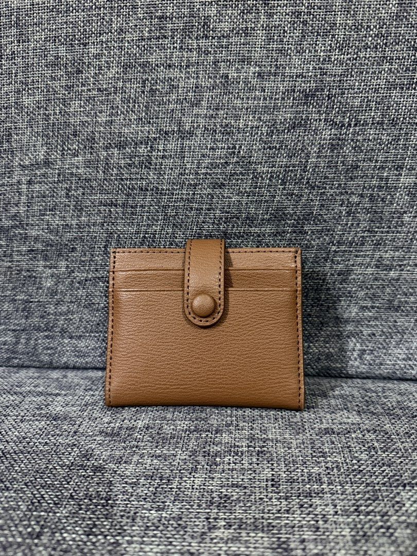 Charles & Keith Brown Card Holder Wallet (Category: Wallets & Card holders) located in Manila. Submitted by hannabananahhh (Listing ID 1466286969, Image 2). Description: - Brand: Charles and Keith - Material: Brown faux leather - Closure: Snap button on the back flap - Storage: Multiple card slots on front, back, and inside - Size: Compact and pocket-friendly - Condition: Clean inside and out with minimal signs of handling.