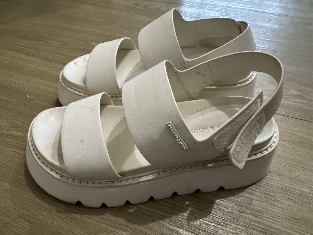 Charles & Keith White Platform Sandals (Category: Sandals) located in Pasig City. Submitted by prelovedby_alexx (Listing ID 1466214023, Image 3). Description: - Brand: Charles & Keith - Color: Creamy off-white - Sole: Chunky lug platform for added height and comfort - Design: Double strap with small metal brand logo plate - Fit: Adjustable velcro back strap - Style: Casual, easy slip-on everyday wear Issues: slight cracking of the leather as seen