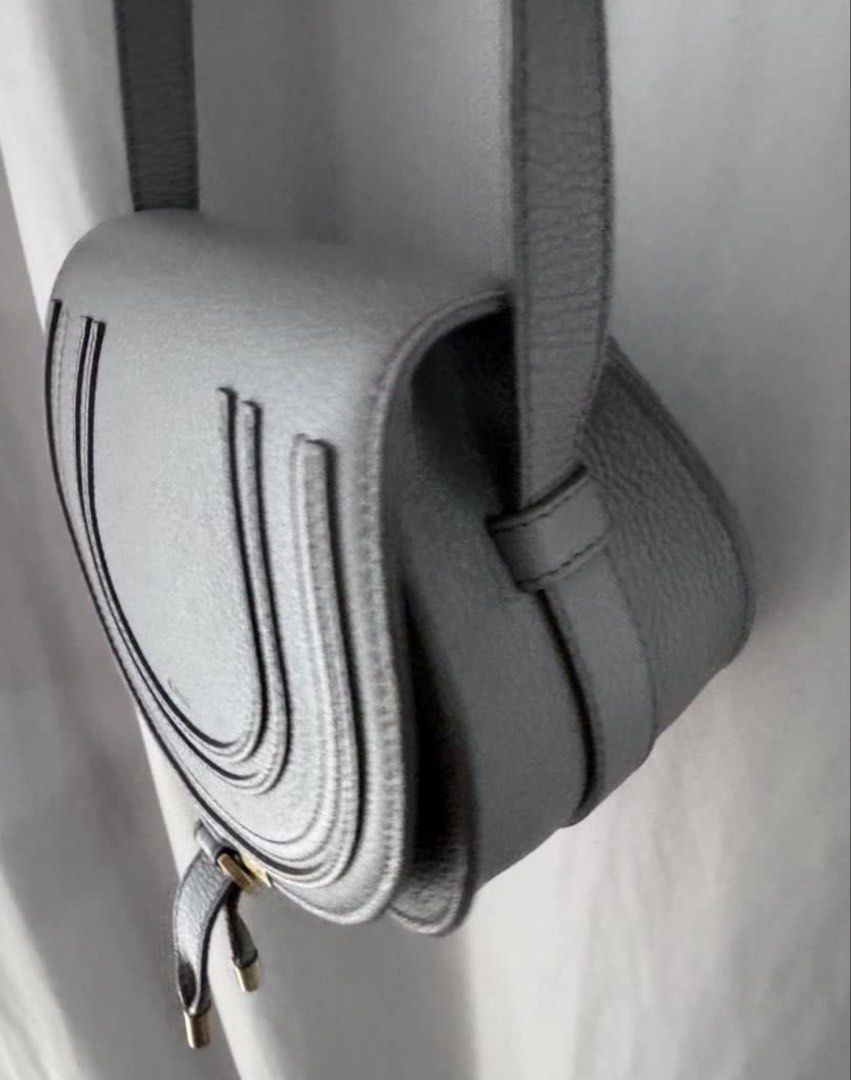 Chloé Marcie Saddle Bag Grey Leather (Category: Luxury Bags & Wallets) located in Manila. Submitted by decluterthings888 (Listing ID 1466335625, Image 2). Description: - Authentic Chloé Marcie crossbody bag in grey textured leather - Signature horseshoe front flap stitching and gold-tone hardware - Slim adjustable shoulder strap for comfortable wear - Fabric-lined interior complete with a handy slip pocket - Includes original dust bag and care ca
