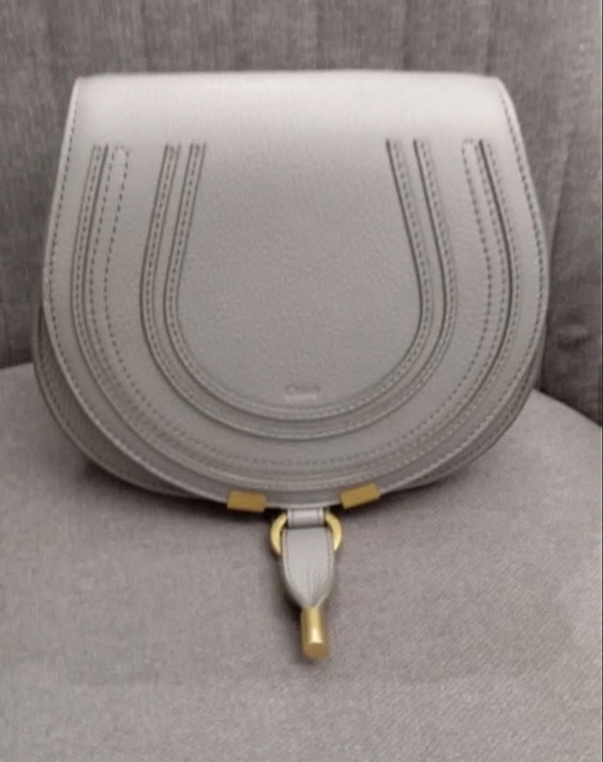Chloe Marcie Saddle Bag Grey (Category: Luxury Bags & Wallets) located in Manila. Submitted by decluterthings888 (Listing ID 1466335683, Image 1). Description: - Authentic Chloé Marcie saddle bag in chic grey grained leather - Signature horseshoe stitching and premium gold-tone hardware - Flap closure with iconic ring and playful tassel drop detail - Comfortable, adjustable crossbody strap for easy wear - Clean interior fabric lining featuring a 