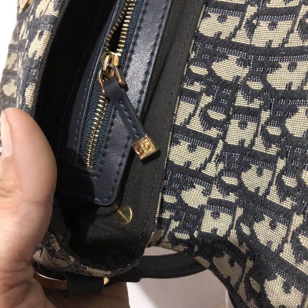 Christian Dior Oblique Saddle Shoulder Bag (Category: Luxury Bags & Wallets) located in Quezon City. Submitted by yunajohan24 (Listing ID 1466250879, Image 3). Description: - Brand: Christian Dior - Style: Saddle Shoulder Bag - Material: Blue and beige Oblique canvas with dark blue leather trim - Hardware: Gold-tone with iconic CD monogram closure - Interior: Black fabric lining with a convenient zippered pocket - Strap: Matching dark blue leathe