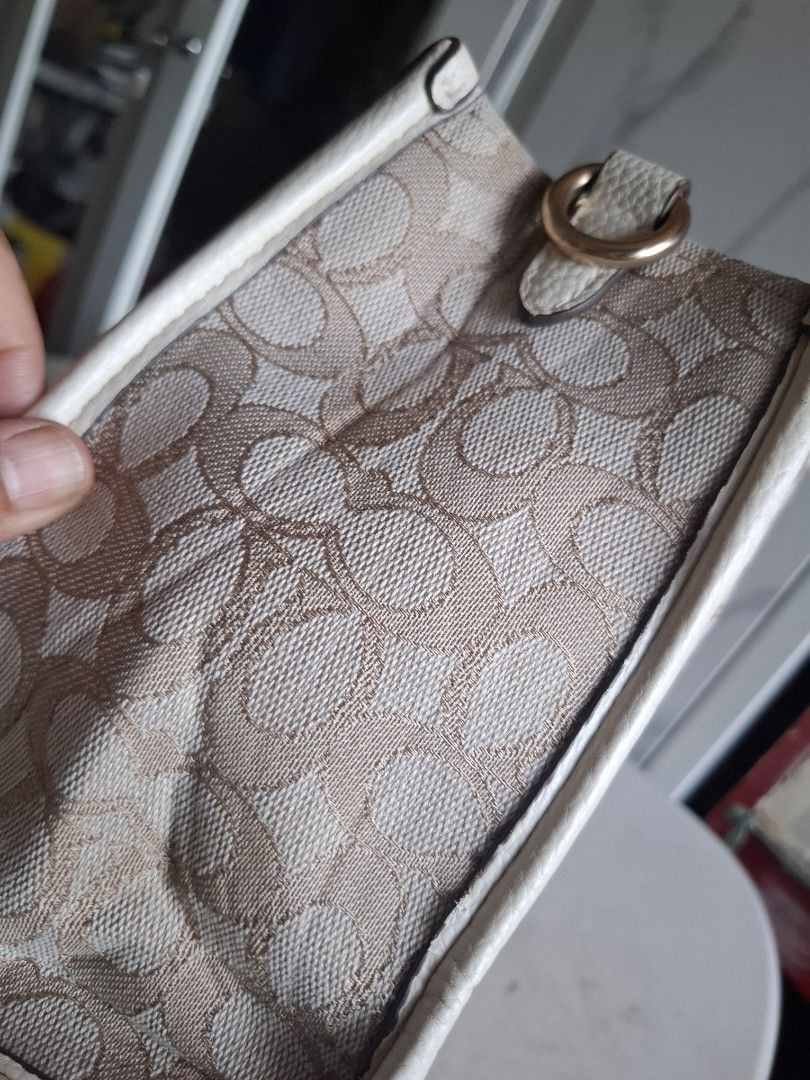 Coach Signature Canvas Tote Bag (Category: Luxury Bags & Wallets) located in Marikina City. Submitted by bags21.ph (Listing ID 1466336757, Image 3). Description: - Authentic Coach signature jacquard canvas tote - Elegant cream leather trim and gold-tone hardware - Classic Coach New York round leather patch with vertical stripe - Structured design with protective metal feet on the bottom - Dual top carry handles and side rings for strap attachment