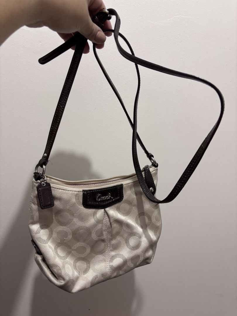 Coach Signature Optic C Small Hobo Bag (Category: Luxury Bags & Wallets) located in Caloocan City. Submitted by stuff_shop (Listing ID 1466293215, Image 3). Description: Coach monogram hobo bag in cream and beige fabric. Dark brown patent leather trim, strap, and Coach logo plaque on the front. Silver-tone hardware. Includes a detachable dark brown strap to wear as a shoulder bag or crossbody. Small Coach leather hangtag attached by a beaded chai