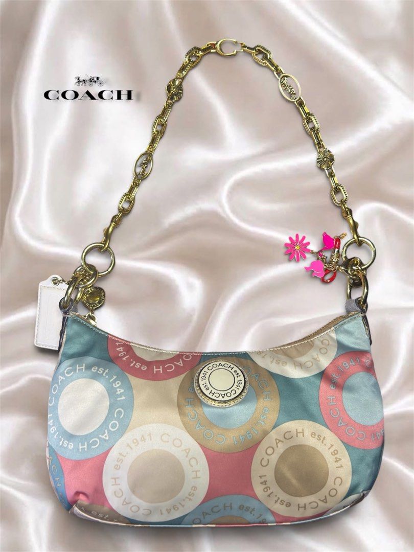 Coach Snaphead Demi Multicolor Satin Shoulder Bag (Category: Luxury Bags & Wallets) located in Cebu City. Submitted by gabgaaab (Listing ID 1466324392, Image 3). Description: - Coach Snaphead Demi Multicolor Satin Shoulder Bag - Excellent Condition - Style: Snaphead Demi Shoulder Bag - Material: Multicolor satin fabric with pastel circles and Coach lettering - Hardware: Gold-tone - Details: Includes pink flower charm and signature Coach hangtag -