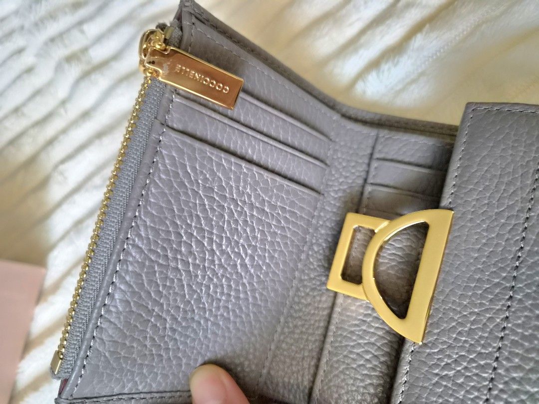 Coccinelle Trifold Leather Wallet with Box (Category: Wallets & Card holders) located in Paranaque City. Submitted by sampgm (Listing ID 1466208850, Image 2). Description: - Brand: Coccinelle - Material: Premium grey pebbled leather - Hardware: Gold-tone with signature clasp closure - Interior: Multiple card slots and secure zippered pocket - Inclusions: Original pink branded box and card - Condition: Well-maintained, minor scratches on hardware 