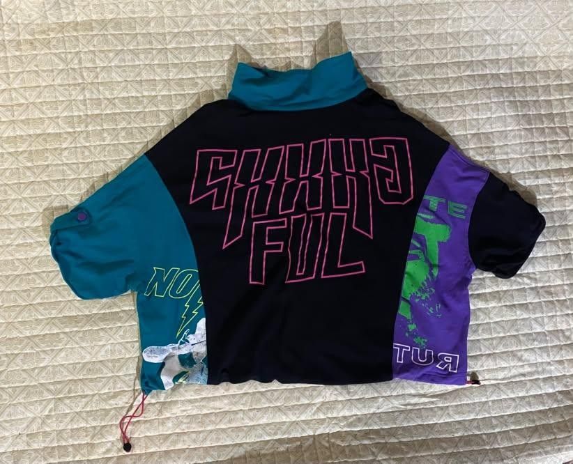 Retro cyberpunk top (Category: Shirts) located in Pagadian. Submitted by kahtlopez47867 (Listing ID 1466276459, Image 2). Description: - Vibrant colorblock design in black, turquoise, and purple - Bold pink graphic text on the back with extra hem print details - Teal collar and button neckline - Short sleeves with button-tab roll-up details - Adjustable drawstring hem for a stylish cropped look Colorblock Graphic Polo Shirt with Drawstring Hem.