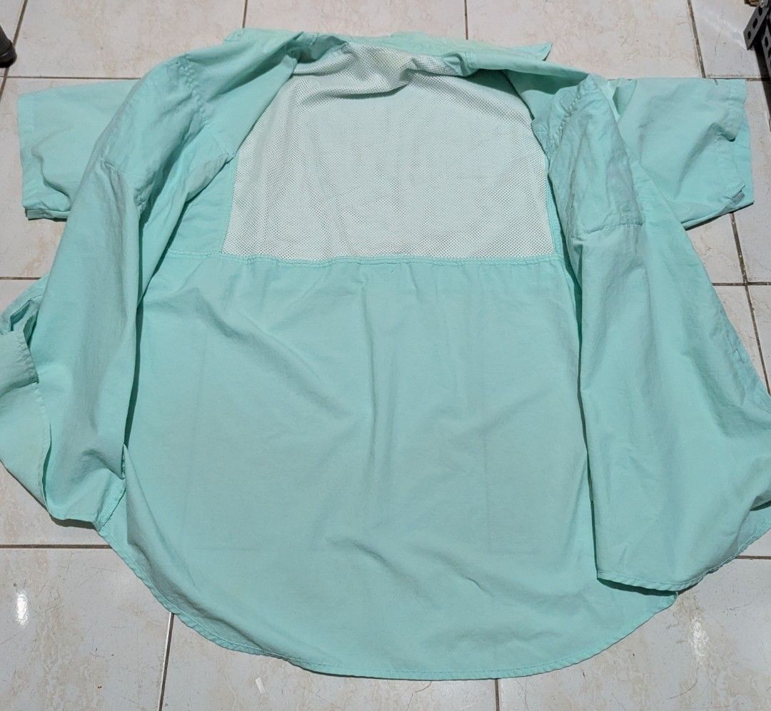 Columbia PFG shirt (Category: Tshirts & Polo Shirts ) located in Malabon City. Submitted by doobidoi (Listing ID 1466217197, Image 3). Description: - Brand/Model: Columbia PFG Fishing Shirt - Color: Light mint green - Size: Large - Width: 24" - Length: 29" Good condition - Closure: Button-up front - Features: Double chest pockets, rod holder loop, and mesh-lined upper back vent for airflow - Fabric: Lightweight and perfect for hot weather outdoor