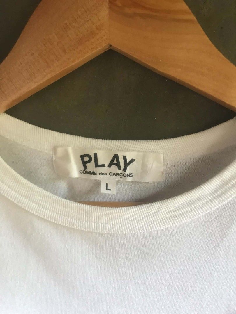 COMME des GARÇONS PLAY White Heart Tee Size L (Category: Shirts) located in Echague. Submitted by jomardofit94339 (Listing ID 1466244285, Image 3). Description: - Brand: Comme des Garçons Play - Color: White - Size: Large (Regular fit) - Design: Iconic red heart patch on -issue stain chest, crew neck, short sleeves - Material: 100% Cotton - Origin: Made in Japan - Condition: / Excellent quality.