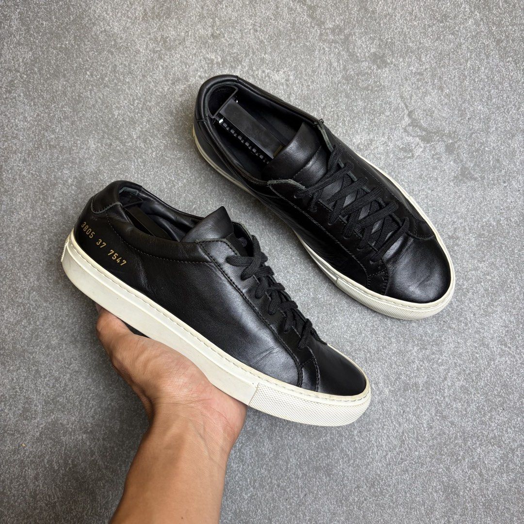 Common Projects Original Achilles Low Black Size 37 (Category: Sneakers) located in Cagayan de Oro. Submitted by taramattsa45690 (Listing ID 1466157767, Image 1). Description: Black leather low-top sneakers from Common Projects. Classic minimalist design with tonal laces and a contrasting white rubber sole. Gold serial number stamped on the heel counter. Leather upper and lining. Regular signs of wear on the soles and midsoles, uppers are clean a