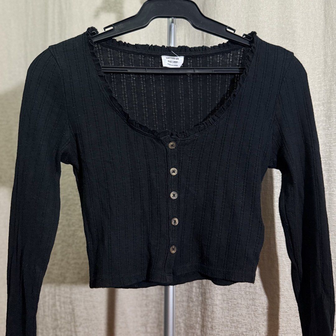 Cotton On Black Ribbed Long Sleeve Top (Category: Longsleeves) located in Manila. Submitted by she_alice (Listing ID 1466325931, Image 1). Description: - Brand: Cotton On - Color: Black - Size: XXS - Material: Lightweight ribbed knit fabric - Design: Scoop neckline with ruffle trim and button-up front with small dark buttons - Condition: Excellent, no noticeable signs of use. 💬 Feel free to message me for any questions 🛵 Can be shipped via Lala