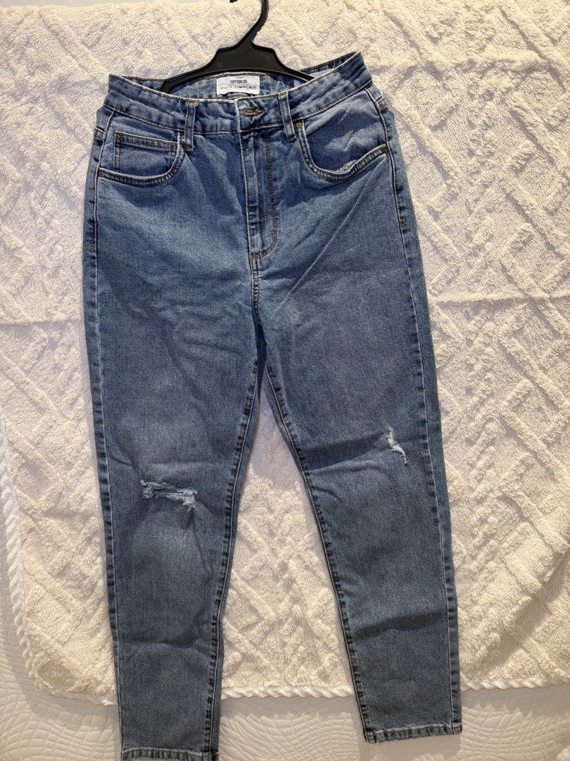 Cotton On Distressed Blue Denim Jeans (Category: Jeans) located in San Juan City. Submitted by ich711 (Listing ID 1466274397, Image 1). Description: - Brand: Cotton On - Wash: Mid-wash blue denim - Fit: High waist with belt loops, straight cut legs, cropped hems - Style: Standard 5-pocket design with button and zip fly closure - Details: Trendy subtle rips on the right knee and left thigh - Condition: Excellent, comfortable for everyday wear - Mo