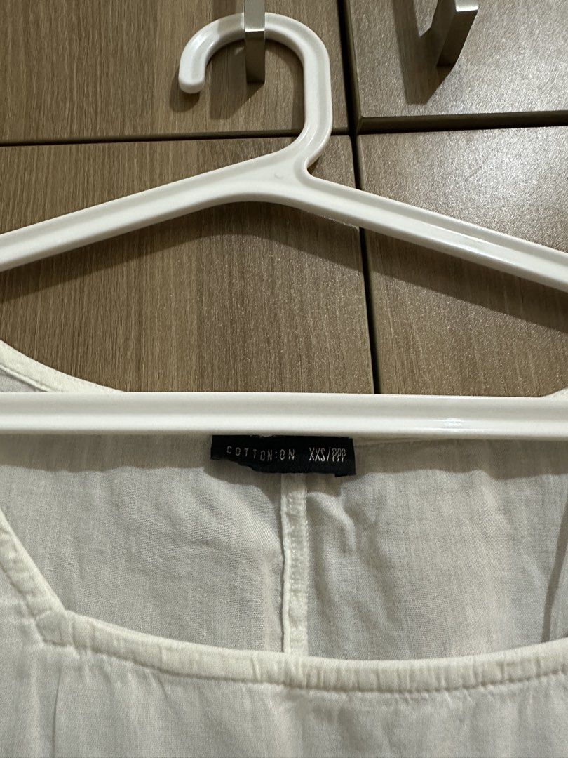 Cotton On White Blouse Square Neck Size XXS (Category: Blouses) located in Quezon City. Submitted by sofieegee (Listing ID 1466295594, Image 2). Description: - Brand: Cotton On - Size: XXS - Color: White (neutral and easy to match) - Details: Square neckline, short puffy sleeves with cuffed hems, front drawstring waist tie, high-low curved hemline - Fabric: Lightweight and slightly sheer - Styling tip: Great to pair with denim or skirts.