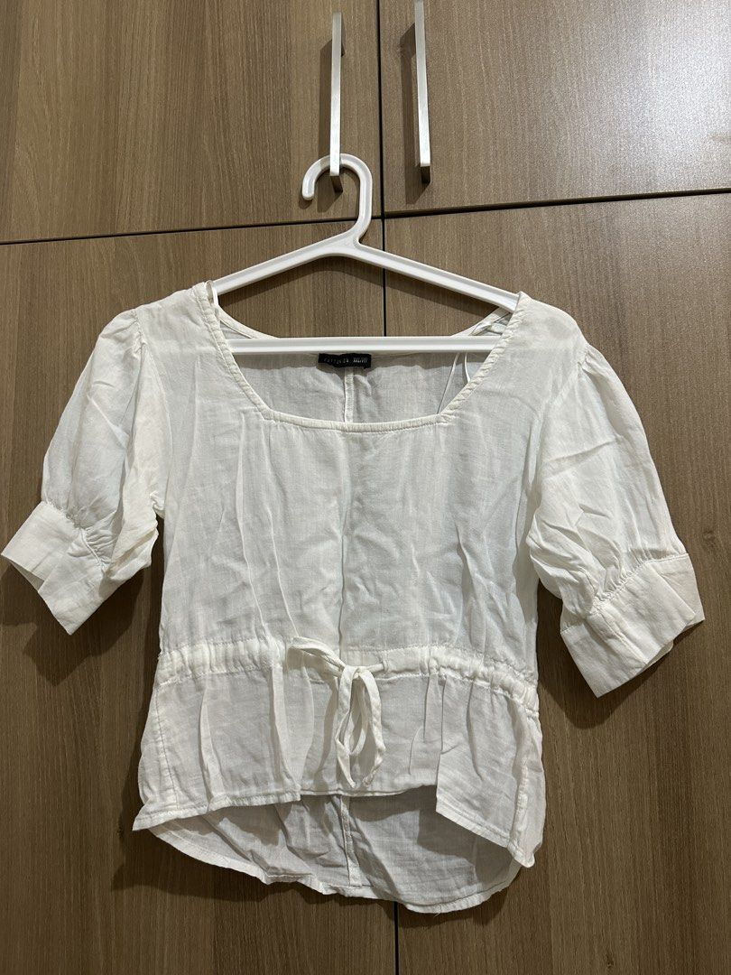 Cotton On White Blouse Square Neck Size XXS (Category: Blouses) located in Quezon City. Submitted by sofieegee (Listing ID 1466295594, Image 1). Description: - Brand: Cotton On - Size: XXS - Color: White (neutral and easy to match) - Details: Square neckline, short puffy sleeves with cuffed hems, front drawstring waist tie, high-low curved hemline - Fabric: Lightweight and slightly sheer - Styling tip: Great to pair with denim or skirts.