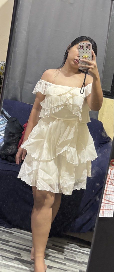 Cream Off-Shoulder Ruffle Mini Dress (Category: Dresses) located in Caloocan City. Submitted by niki.niki. (Listing ID 1466332111, Image 1). Description: - Color: Off-white - Style: Off-shoulder, sleeveless, flared silhouette - Details: Layered ruffles across the chest and skirt - Length: Above the knee - Fabric: Lightweight and comfortable - Perfect for: Casual days, weekend outings, easy to style with sandals or heels.