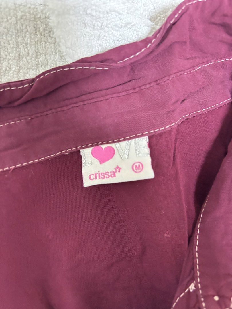 Crissa Maroon Button-Down Shirt Size M (Category: Blouses) located in Balagtas. Submitted by prelovedbyshai_ (Listing ID 1466255287, Image 2). Description: - Brand: Crissa - Size: Medium - Color: Maroon with contrasting white stitching - Details: Two chest pockets with button flaps, front button closure, button cuffs on long sleeves - Fabric: Lightweight and comfortable - Condition: Excellent, easy to style for casual looks.
