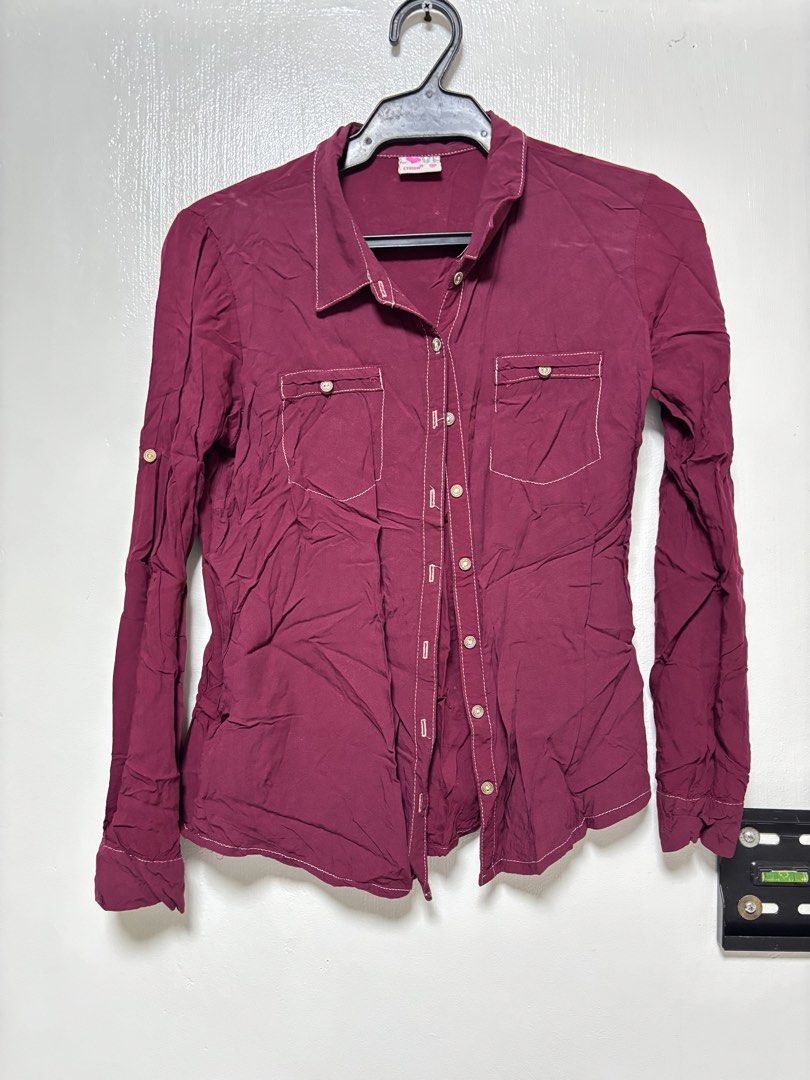 Crissa Maroon Button-Down Shirt Size M (Category: Blouses) located in Balagtas. Submitted by prelovedbyshai_ (Listing ID 1466255287, Image 1). Description: - Brand: Crissa - Size: Medium - Color: Maroon with contrasting white stitching - Details: Two chest pockets with button flaps, front button closure, button cuffs on long sleeves - Fabric: Lightweight and comfortable - Condition: Excellent, easy to style for casual looks.