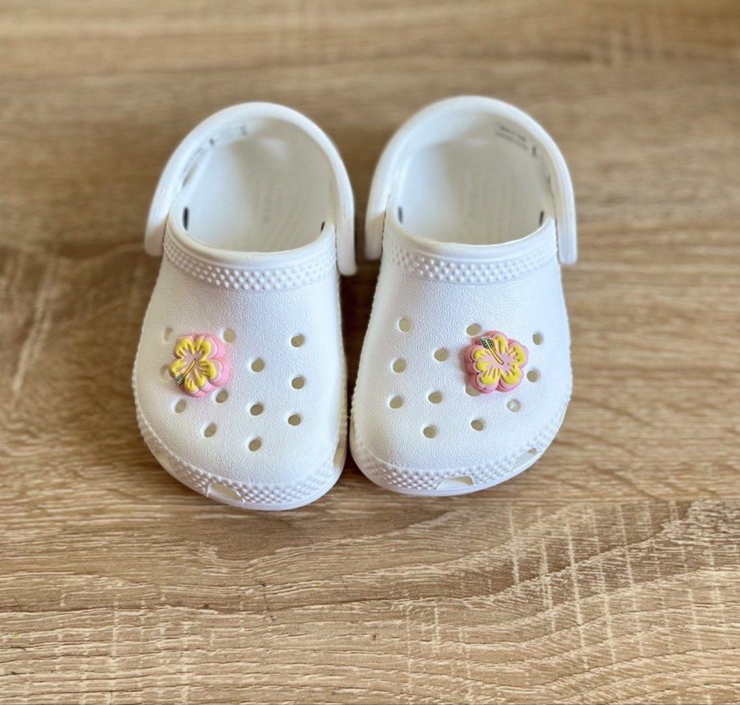 Crocs white c4 (Category: Babies & Kids Fashion) located in General Santos City (Dadiangas). Submitted by my_lzlove (Listing ID 1466336164, Image 2). Description: - Color: White with pink and yellow flower charms - Size: Toddler - Style: Easy slip-on with secure heel straps - Material: Lightweight foam - Best for: Playground, beach days, and everyday wear - Condition: Clean overall.