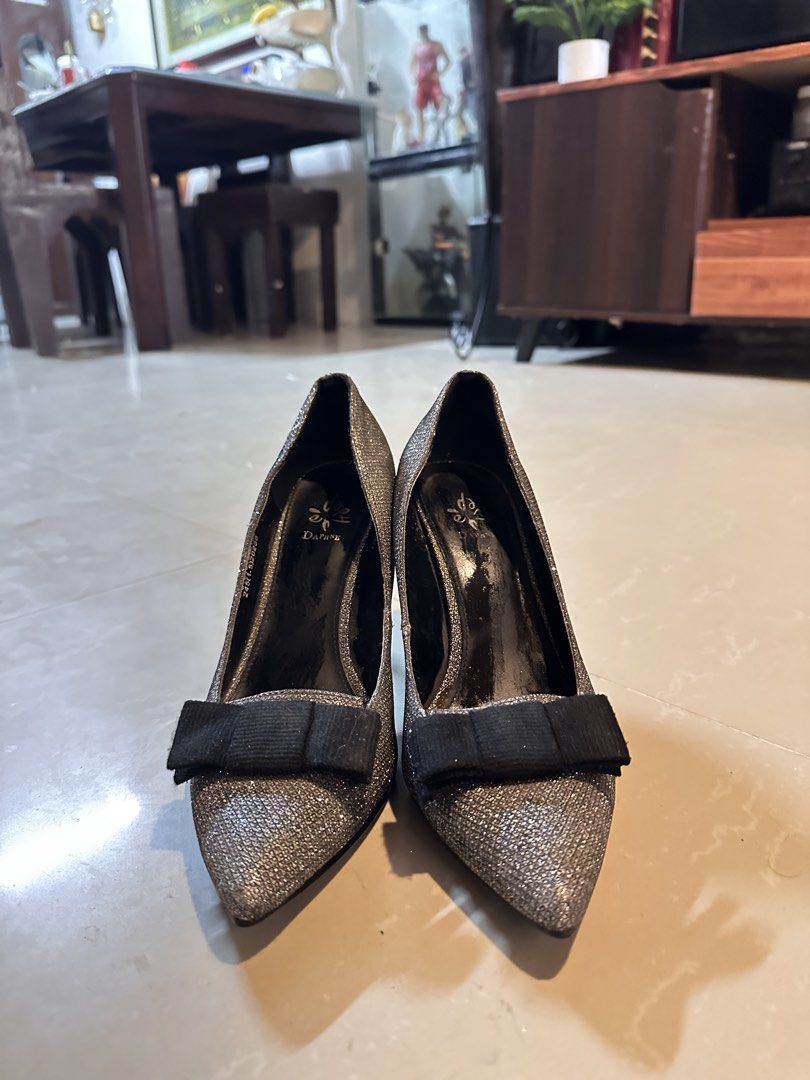 Daphne Silver Glitter Stiletto Heels with Bow (Category: Heels) located in Manila. Submitted by mysticdog_8e9243 (Listing ID 1466181154, Image 2). Description: - Brand/Model: Daphne Pointed-Toe Heels - Color: Sparkling silver with a contrasting black fabric bow on the front - Heel: Sleek stiletto with a black stiletto base - Sole: Textured underneath for better grip and slip resistance - Style: Classic slip-on pumps - Occasion: Ideal for parties,
