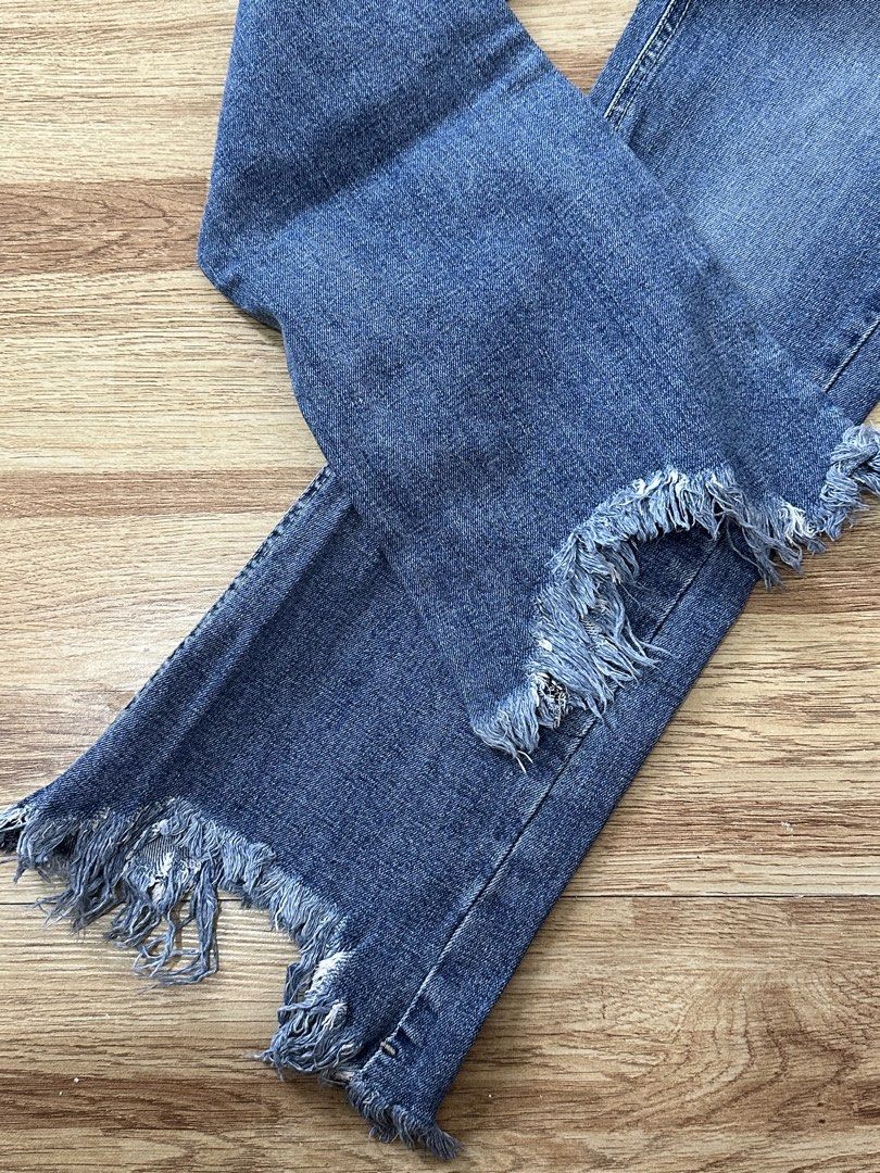 DARIMI Blue Distressed Hem Denim Jeans (Category: Jeans) located in Manila. Submitted by allana18 (Listing ID 1466217281, Image 3). Description: - Brand: DARIMI - Wash: Medium blue denim - Fit: High-waist with front button and zipper closure - Design: Classic five-pocket style with subtle distressing on rear pockets - Hem: Unique frayed, uneven raw hem at the ankles - Material: Sturdy, structured denim fabric.