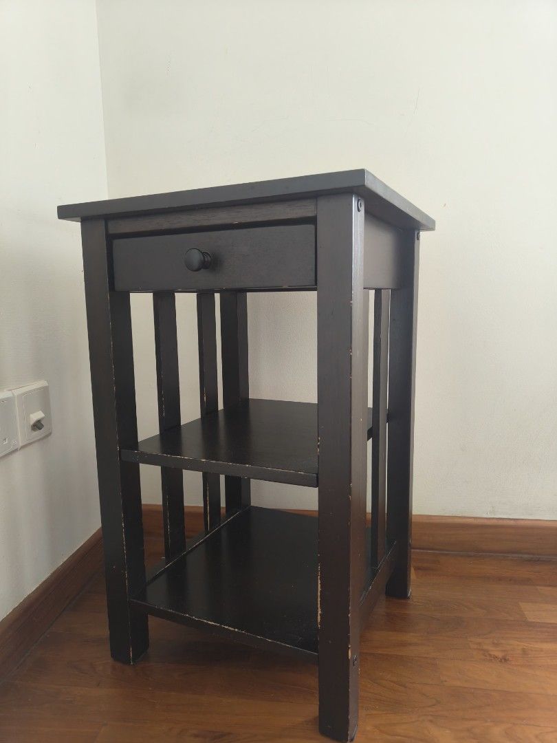 Side table (Category: Shelves, Cabinets & Racks) located in Singapore. Submitted by minml (Listing ID 1466201994, Image 2). Description: - Dark brown solid wood side table - 1 pull-out drawer with a black knob - 2 open lower shelves - Dimensions: height 61cm, 38cm x 38cm - side edges paint wear off. - pick up balestier/toa payoh.
