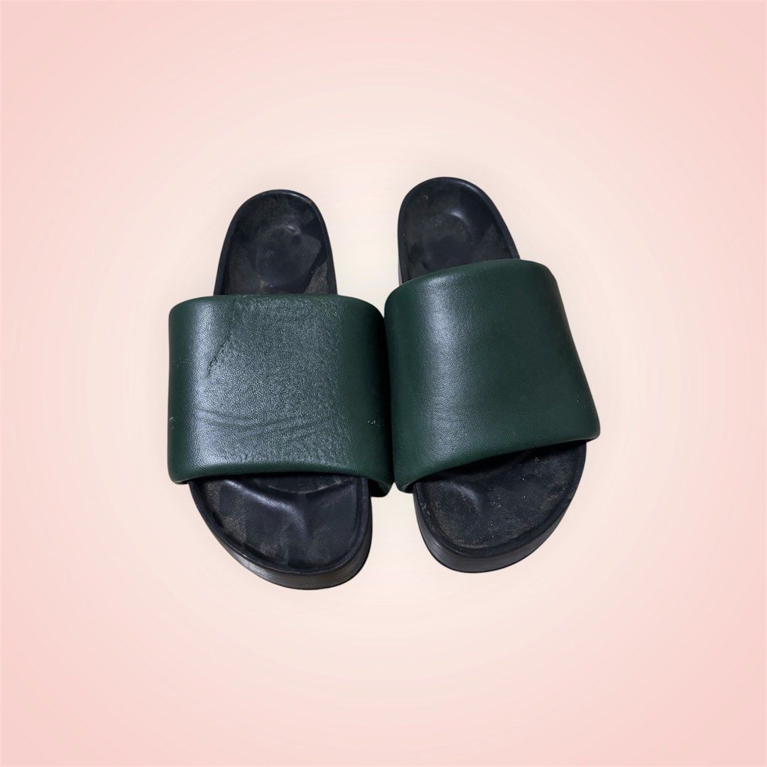 Dark green leather slides slip-on sandals (Category: Flats & Sandals) located in Rosario. Submitted by preloveditems2002 (Listing ID 1466242420, Image 1). Description: - Color: Dark green with black footbed - Material: Quality leather with a wide top strap - Style: Flat chunky sole, easy slip-on - Condition: Normal wear on inner footbeds from regular use, solid construction - Perfect for: Casual days out and running errands - Brand: Celine - need