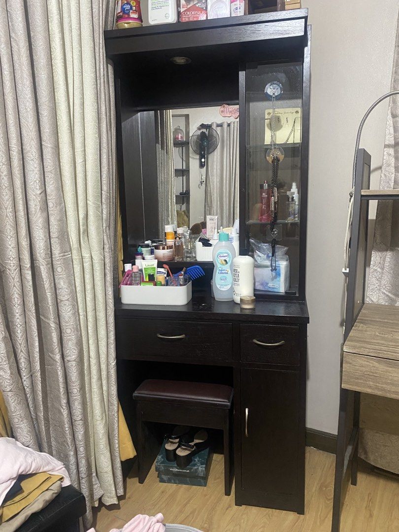 Dark Wood Vanity Table with Mirror and Stool (Category: Tables & Sets) located in Bacoor. Submitted by thalia.maria (Listing ID 1466331382, Image 1). Description: - Color/Material: Sturdy dark brown wood finish - Features: Built-in mirror, glass-door cabinet, main drawer, lower cabinet, and top shelf - Inclusion: Matching cushioned stool (neatly stores underneath) - Condition: Excellent (accessories shown are not included) - Perfect for organizin