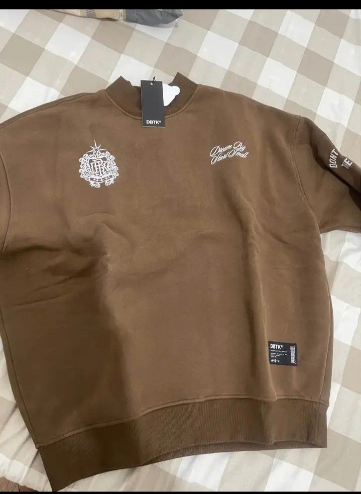 DBTK Regal Crewneck Brown Medium (Category: Coats, Jackets and Outerwear) located in Makati City. Submitted by sommersettanaka (Listing ID 1466330688, Image 3). Description: - Brand: DBTK (Regal Crewneck) - Color: Brown - Size: Medium - Condition: Brand new with tags (BNWT) in original plastic packaging - Design: White graphic prints on front and back with 'DREAM BIG START SMALL' text - Details: Ribbed collar, cuffs, and hem.