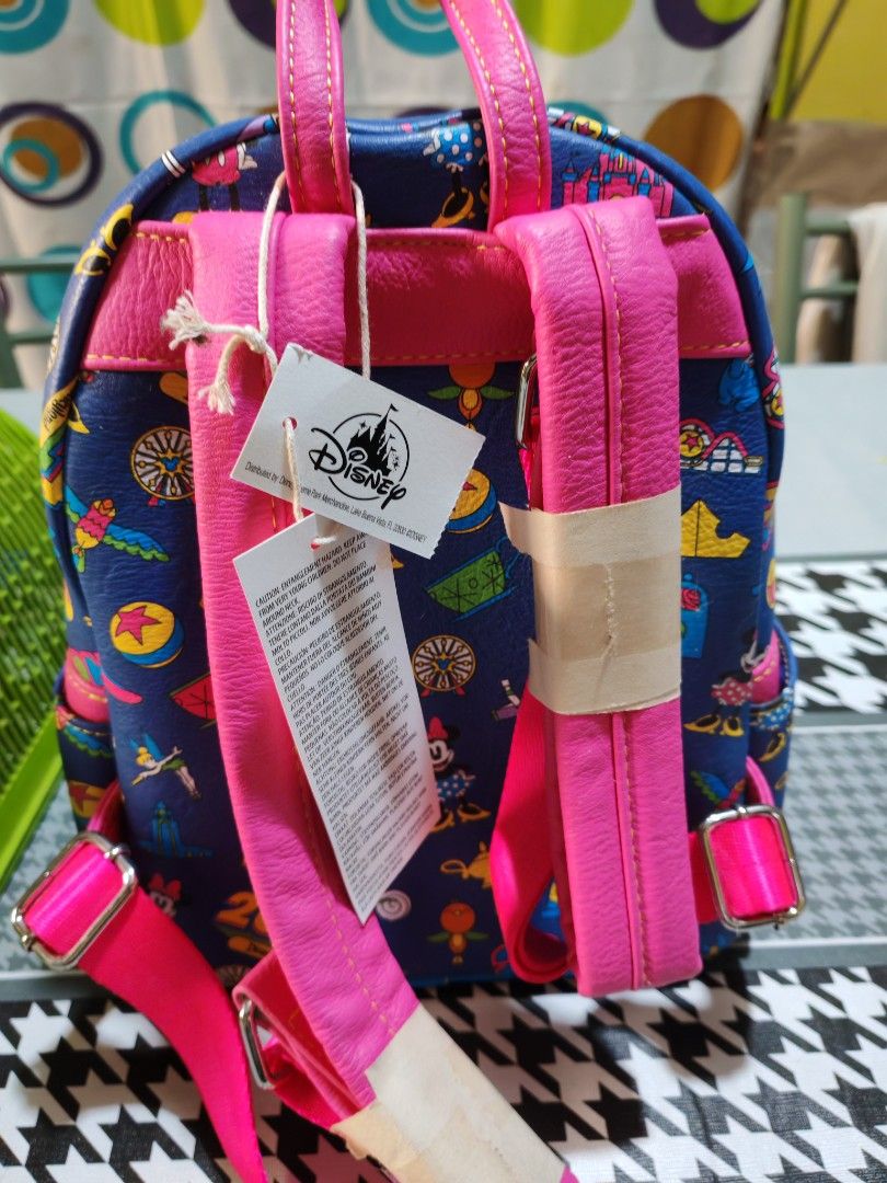 Disney Parks Loungefly Mini Backpack (Category: Babies & Kids Fashion) located in Makati City. Submitted by mccuachon (Listing ID 1466258766, Image 2). Description: - Authentic Disney Parks x Loungefly Disneyland 2024 mini backpack - Material: Blue faux leather with vibrant pink straps and handle - Design: All-over print featuring Mickey, Minnie, Tinker Bell, and Buzz Lightyear - Features: Bright blue zipper trim, front zipped pocket, and officia