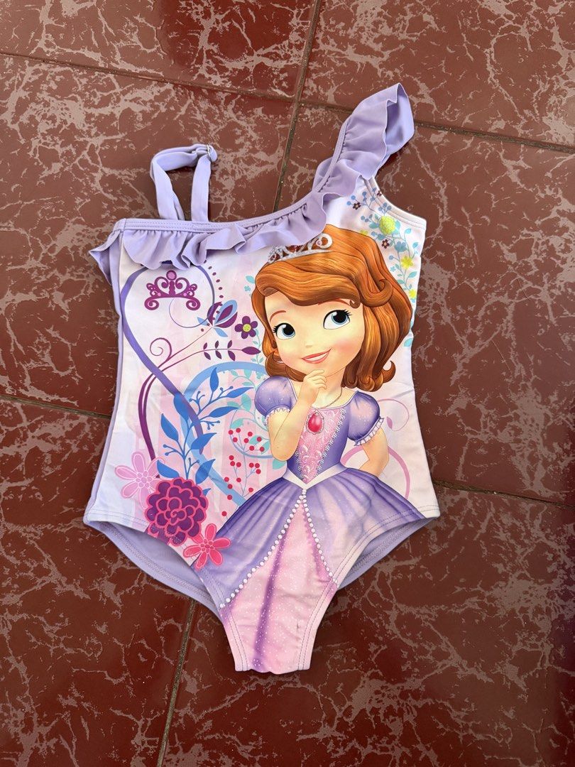 Disney Princess Sofia the First One-Piece Swimsuit Size S (Category: Bikinis & Swimsuits) located in Las Pinas. Submitted by piwiealcantara (Listing ID 1466181272, Image 1). Description: - Authentic Disney Sofia the First one-piece swimsuit - Color: Light purple with soft white inner lining - Size: S (tag attached inside) - Design: Princess Sofia front graphic print - Details: Ruffled neckline, one adjustable shoulder strap, and one ruffled strap