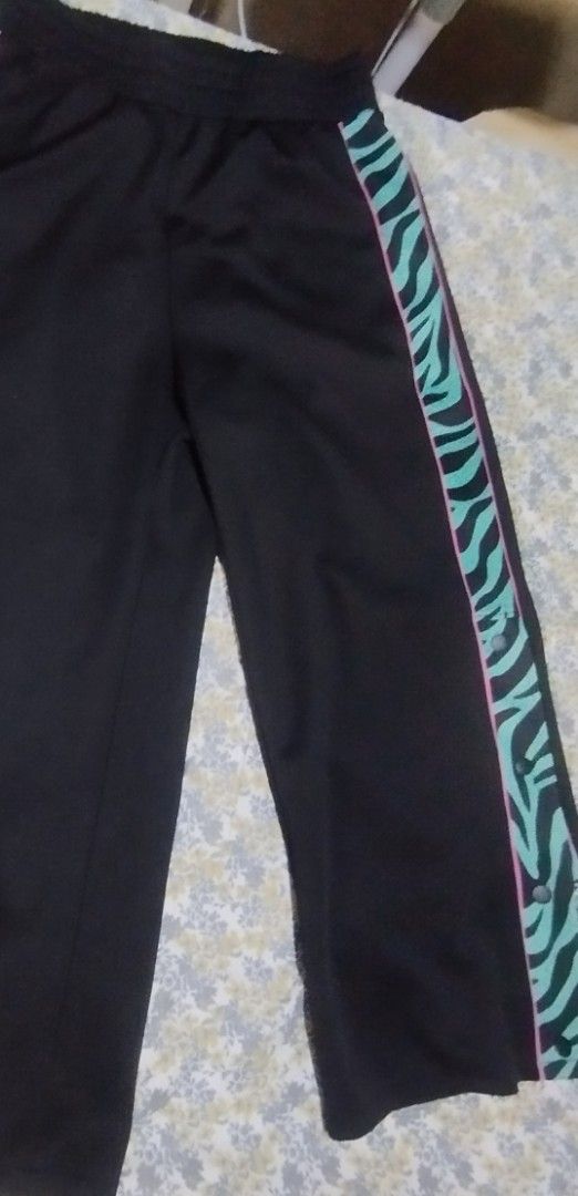 Divided H&M Black Zebra Side Snap Track Pants (Category: Other Bottoms) located in Manila. Submitted by lene48 (Listing ID 1466251791, Image 1). Description: - Brand: H&M Divided - Color: Black with green & pink zebra print side stripes - Features: Trendy snap button closures down the legs - Fit: Relaxed fit with a comfortable elastic waistband - Material: Soft and lightweight polyester32 to 34 waist - Perfect for: Casual wear, streetwear, and K-