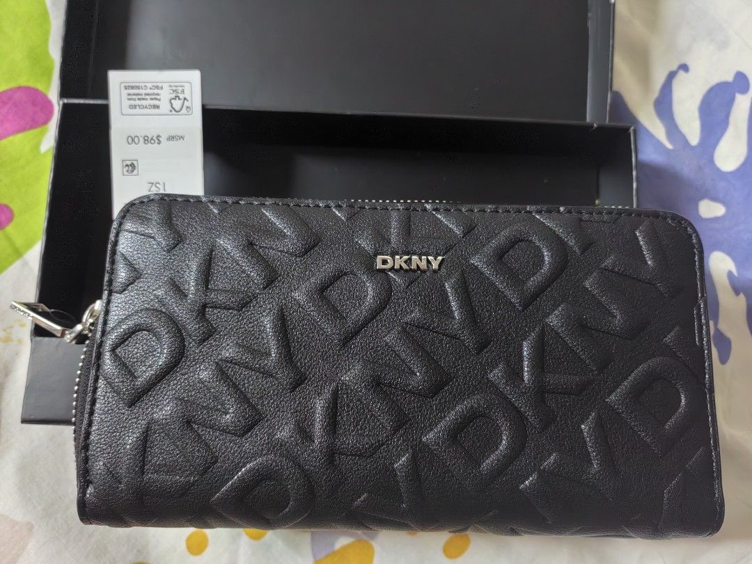 DKNY Black Embossed Logo Zip Around Wallet With Box (Category: Wallets & Card holders) located in Pasay City. Submitted by 3j_shop (Listing ID 1466256029, Image 2). Description: - Brand: DKNY - Color: Classic Black - Design: All-over debossed logo patt ern with front metal logo plate - Hardware: Silver-tone - Closure: Secure zip-around - Condition: Brand new with store tag attached (MSRP $98) - Inclusion: Original black DKNY branded box.