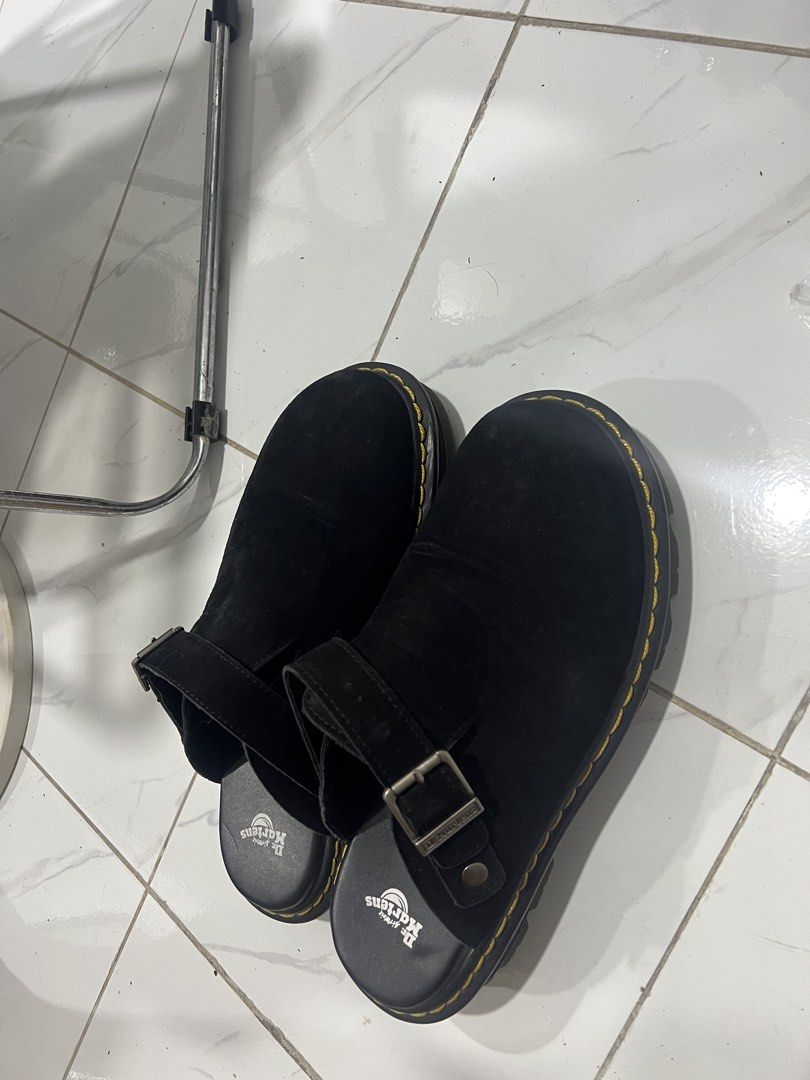 Dr. Martens Black Suede Mules (Category: Flats & Sandals) located in Manila. Submitted by magnuscastle (Listing ID 1466293902, Image 1). Description: - Brand: Dr. Martens - Style: Black suede mules / slip-on - Details: Adjustable strap with metal buckle, classic yellow contrast stitching - Comfort: Padded leather footbed with logo stamp - Sole: Thick grooved sole with very minimal signs of wear - Condition: Clean upper, well-maintained.