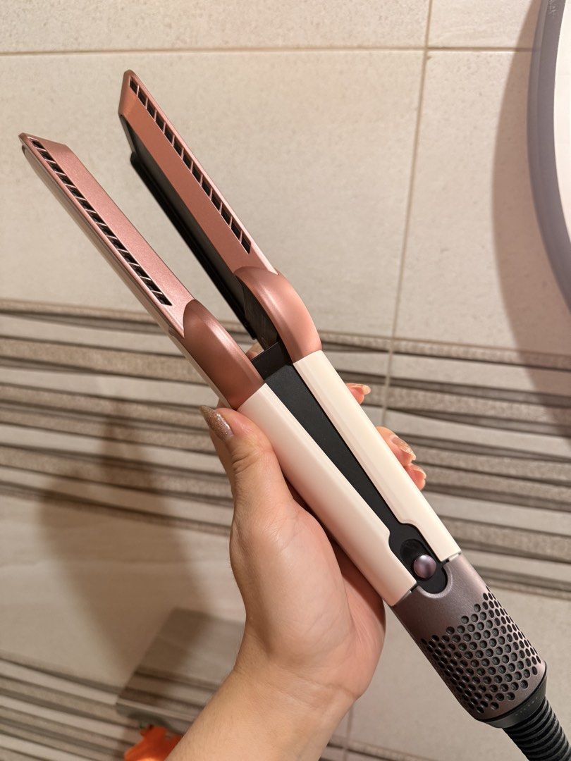 Dyson Airstrait ceramic hair styling tool (Category: Hair) located in San Fernando. Submitted by ymnej1201 (Listing ID 1466170453, Image 1). Description: - Authentic Dyson Airstrait Wet-to-Dry Straightener - Color: Ceramic Pink and Rose Gold - Airflow technology dries and straightens simultaneously without hot plates - Digital LCD screen for easy airflow and temperature control - Complete with the bulky PRCD safety plug and built-in instructions 