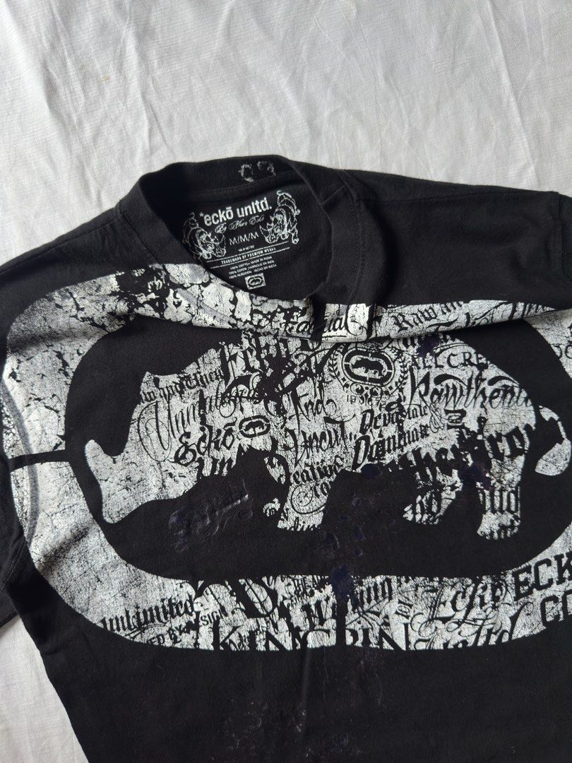 ECKO SHIRT (Category: Tshirts & Polo Shirts ) located in Davao. Submitted by kelsocool (Listing ID 1466255903, Image 2). Description: Ecko Unltd. Big Logo Graphic Tee Dimes (inch): 25.5 - length 19.5 - width 9 - sleeve color rate: 10/10 no issue good condition Model: 5’5 ft/ 54 kg Description: Classic 2000s Y2K skater/hip-hop streetwear tee featuring an oversized center rhino logo surrounded by script text print details..