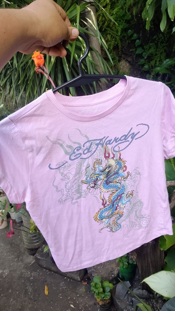 Ed Hardy Pink Dragon Crop Top Size M (Category: Shirts) located in Morong. Submitted by sanjuancla56319 (Listing ID 1466207436, Image 1). Description: - Brand: Ed Hardy - Style: Crop top - Color: Light pink - Design: Blue and yellow dragon graphic with signature script logo on front and back - Size: Medium - Material: Cotton and polyester blend - Care: Machine washable.
