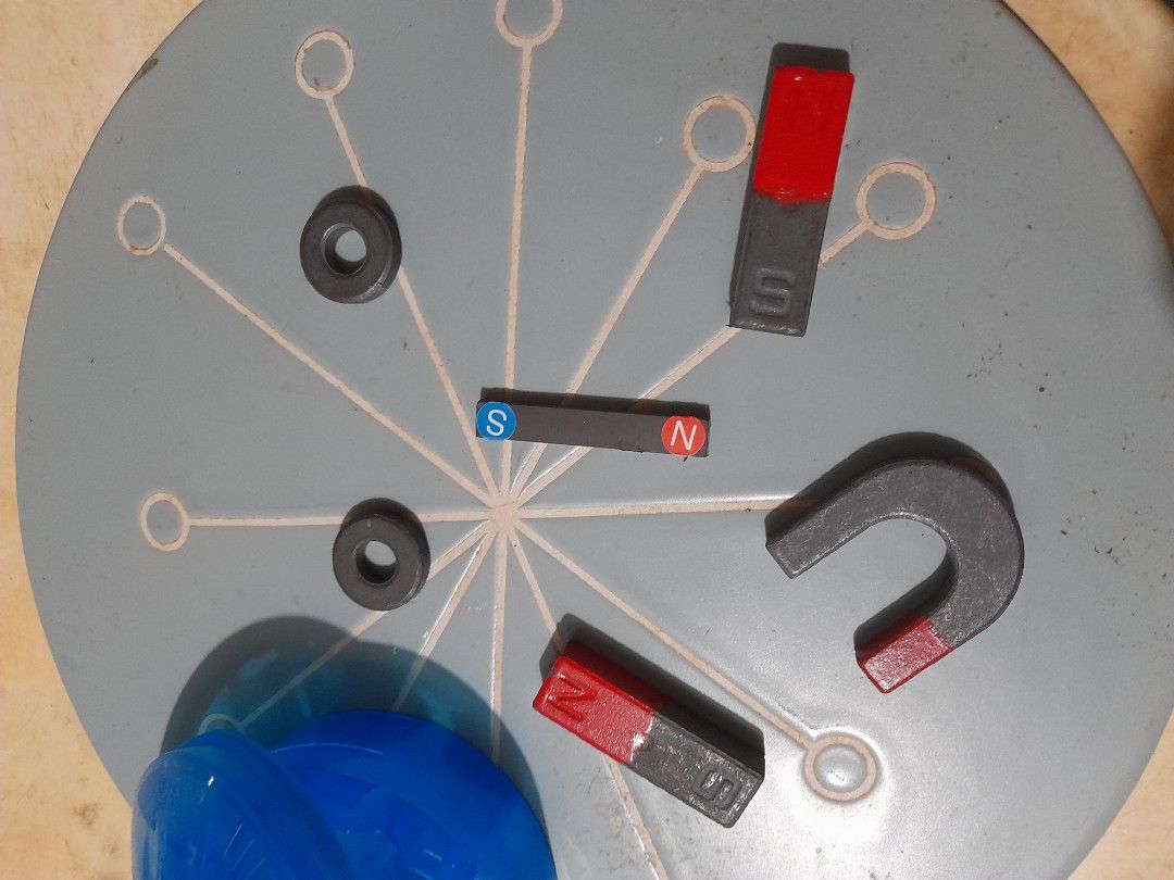 Educational Magnet Set (Category: Educational & Learning Toys) located in Bocaue. Submitted by marajapansurplus (Listing ID 1466174933, Image 2). Description: - Includes horseshoe magnet, bar magnets, ring magnets, and a small rectangular piece - All pieces clearly marked with North (N) and South (S) poles - Features bright red painted ends on several pieces - Comes in a convenient round blue plastic storage container with a fitted lid and organi