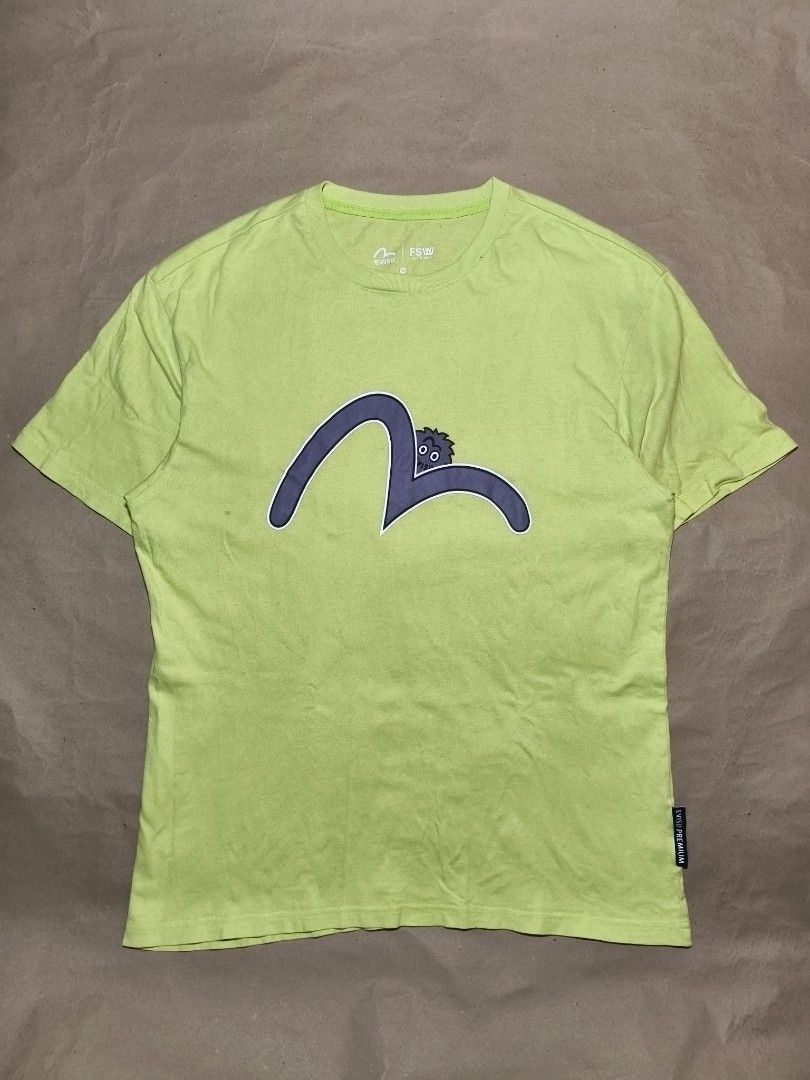 Evisu Lime Green Graphic T-Shirt (Category: Tshirts & Polo Shirts ) located in Manila. Submitted by thriftclothin (Listing ID 1466301726, Image 1). Description: - Brand: Evisu - Color: Bright lime green with a large purple graphic logo - Features: Short sleeves, crew neck, small branded black tag at the hem, Korean inner wash tag with QR code - Condition: Minor fabric wear and a faint stain near the lower left front graphic - Authentic streetwear