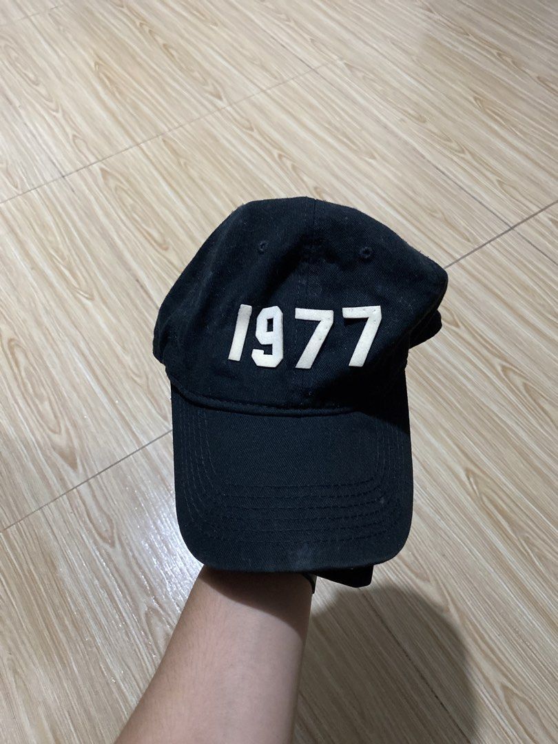 Fear of God Essentials 1977 Black Cap (Category: Caps & Hats) located in Davao. Submitted by jayelcarba61168 (Listing ID 1466314611, Image 1). Description: - Brand: Fear of God Essentials - Color: Black with white "1977" embroidery - Details: Essentials logo metal buckle, rubber label on the back - Fit: Adjustable strapback (one size fits most) - Condition: Brand new / Excellent quality - Style: Versatile streetwear staple, easy to match with dai