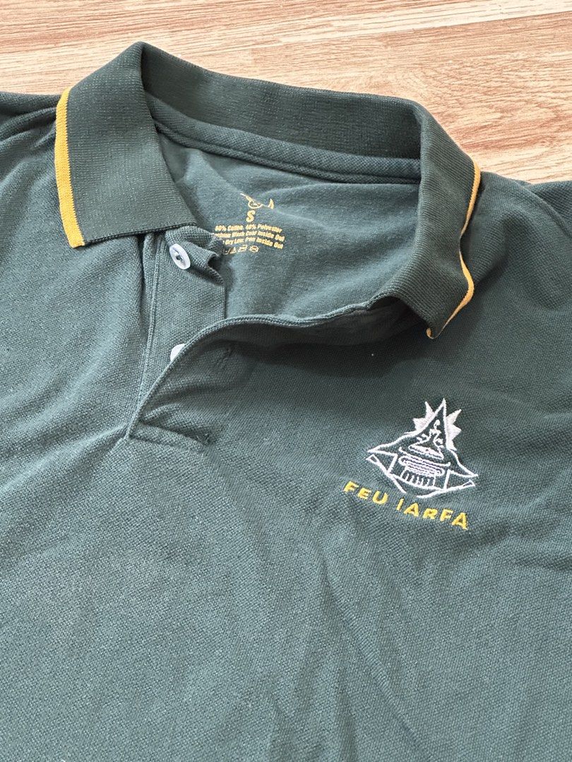 FEU IARFA Green Polo Shirt Size S (Category: Tshirts & Polo Shirts ) located in Manila. Submitted by allana18 (Listing ID 1466219511, Image 1). Description: - Brand: FEU IARFA - Color: Dark green with yellow piping details on collar and sleeves - Size: S - Material: Cotton-polyester blend - Features: Embroidered chest logo, two-button placket - Condition: Excellent, clean fabric with no obvious flaws.